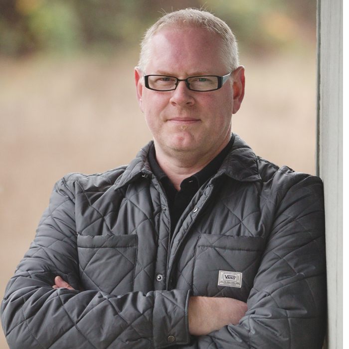 Man standing with arms crossed looking at camera.